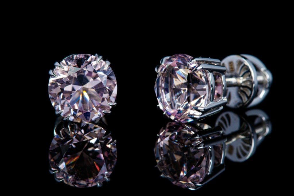 beautiful gold earrings with morganite gemstones on a black background close-up